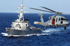 An Mh-60s Knighthawk Helicopter Flies By The Guided Missile Destroyer Uss John S. Mccain (ddg 56) Image