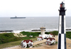 Precommissioning Unit (pcu) Ronald Reagan (cvn 76) Passes A Lighthouse Located At Fort Story Army Base Image