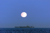 A Full Moon Illuminates The Nuclear Aircraft Carrier Carl Vinson. Image