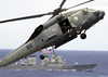 An Sh-60 Seahawk Helicopter Slows Down To Lower It Image